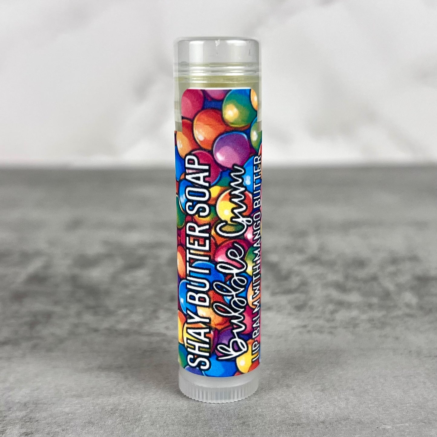 Bubble Gum lip balm with a colorful label on a gray background