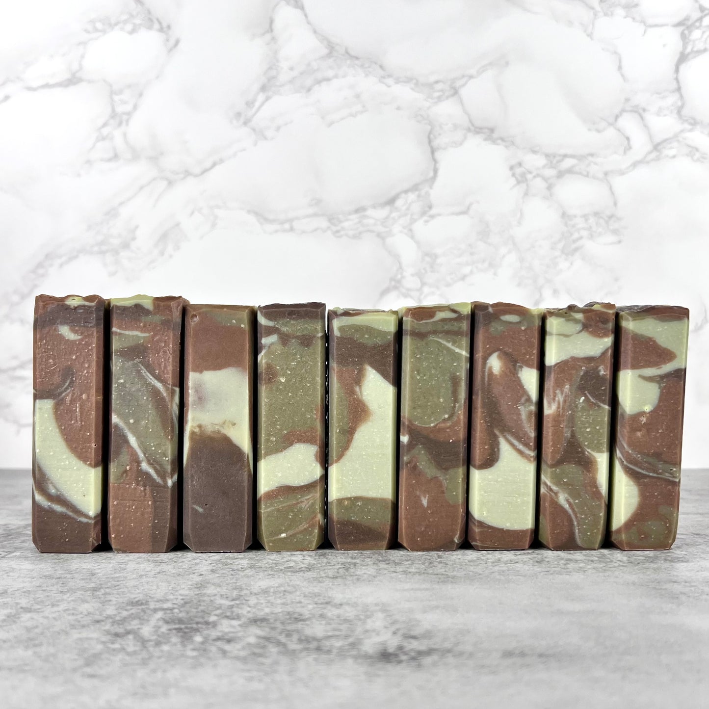 Camouflage-patterned soap bars arranged on a marble surface