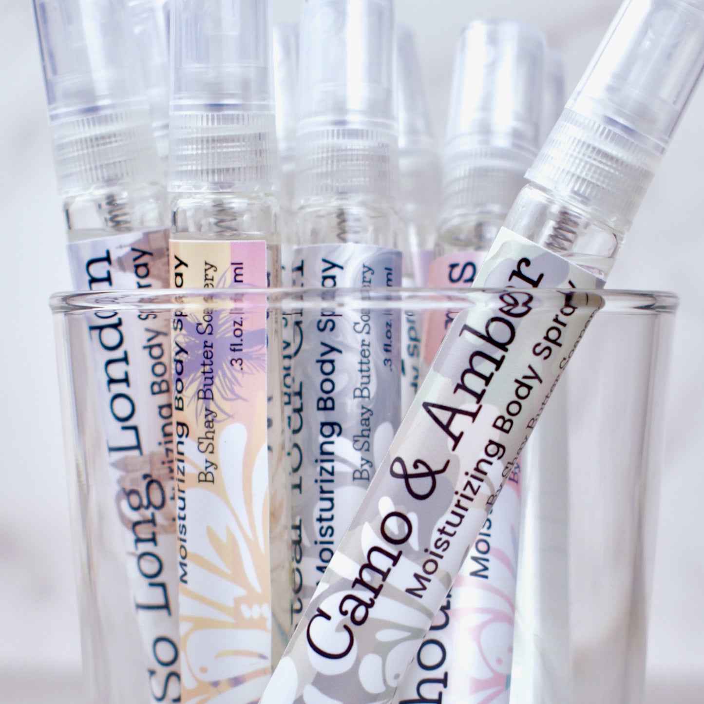 Clear spray bottles with labels on a white background