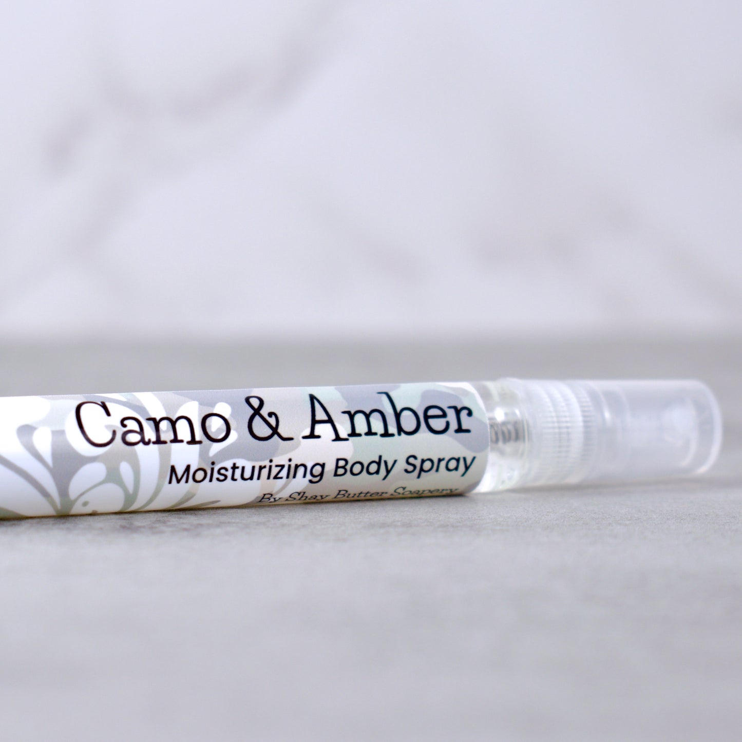 Camo & Amber moisturizing body spray on a light gray background