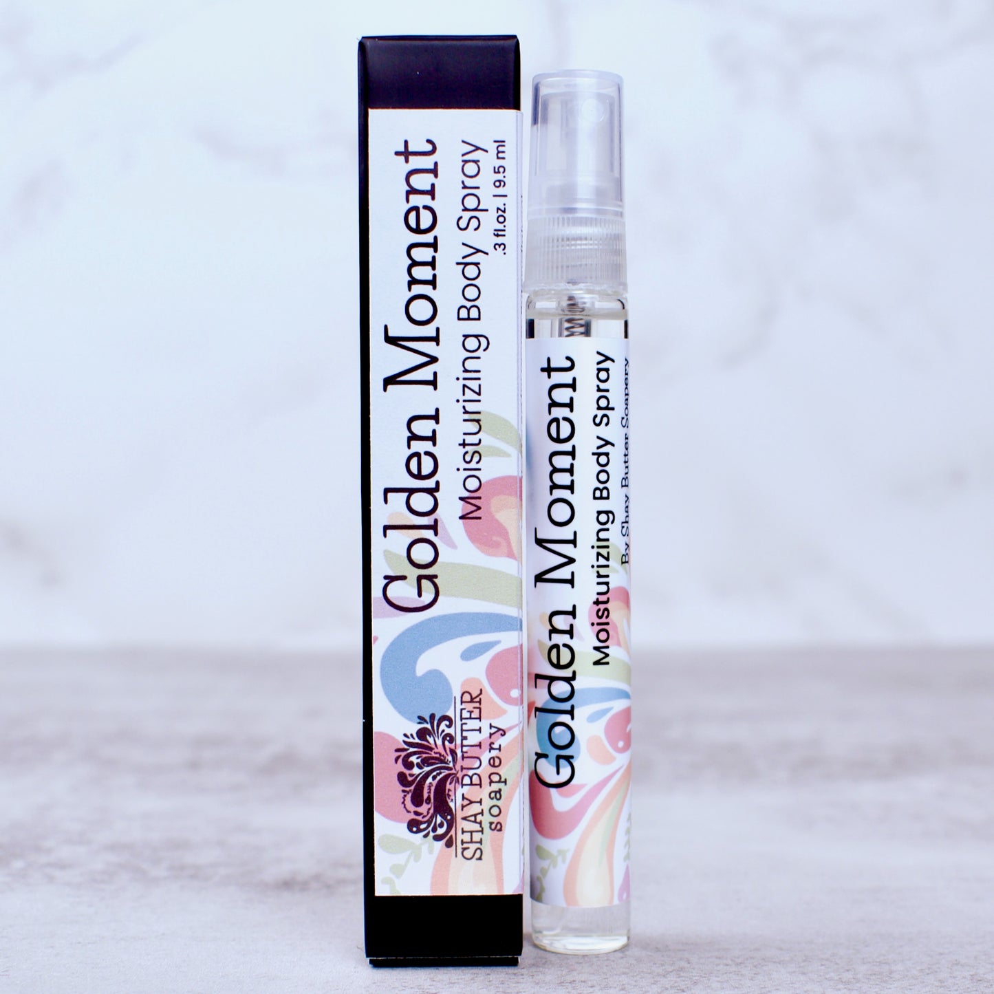 Golden Moment moisturizing body spray with packaging on a light gray background