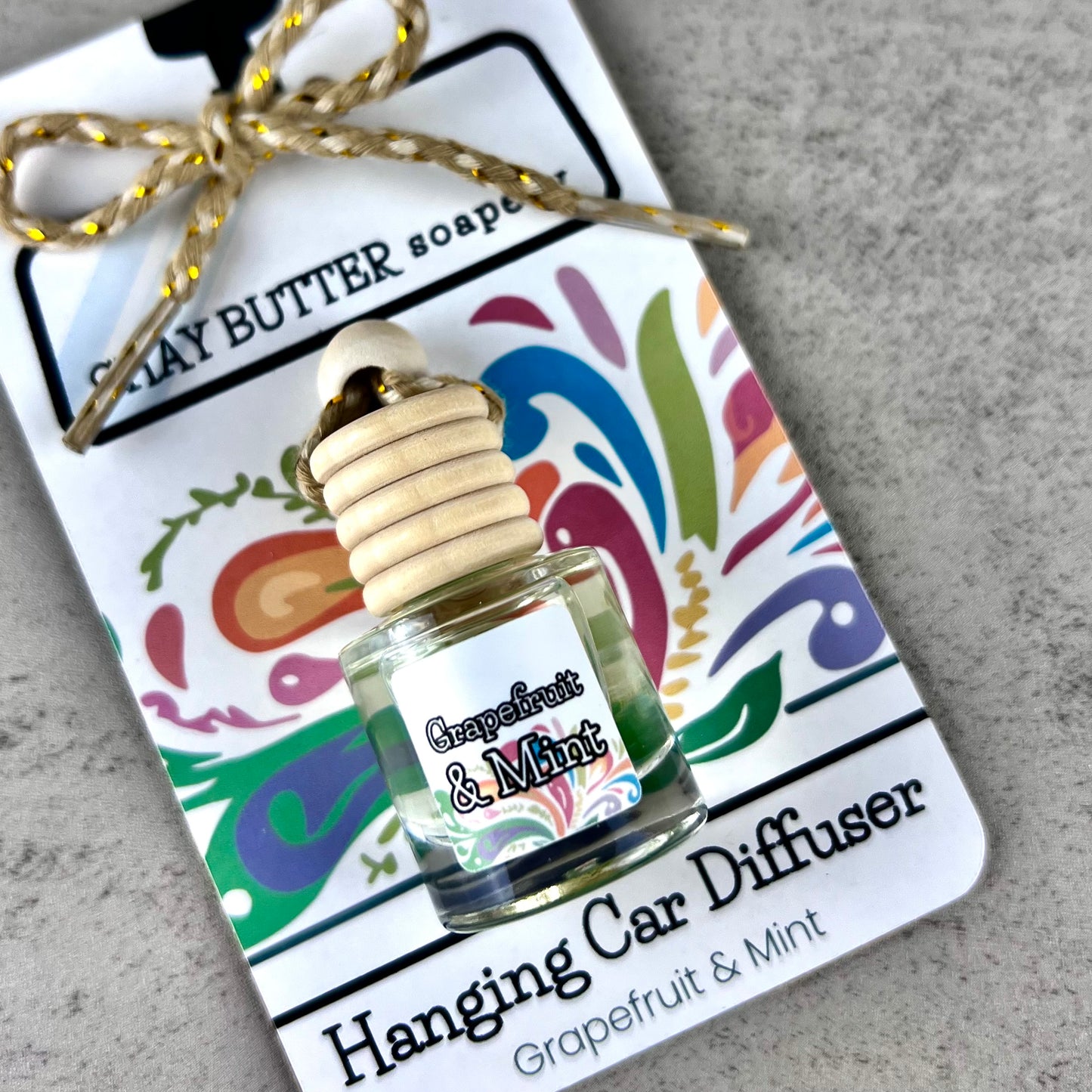 Grapefruit & Mint Hanging Car Diffuser on a decorative card packaging with a gray background