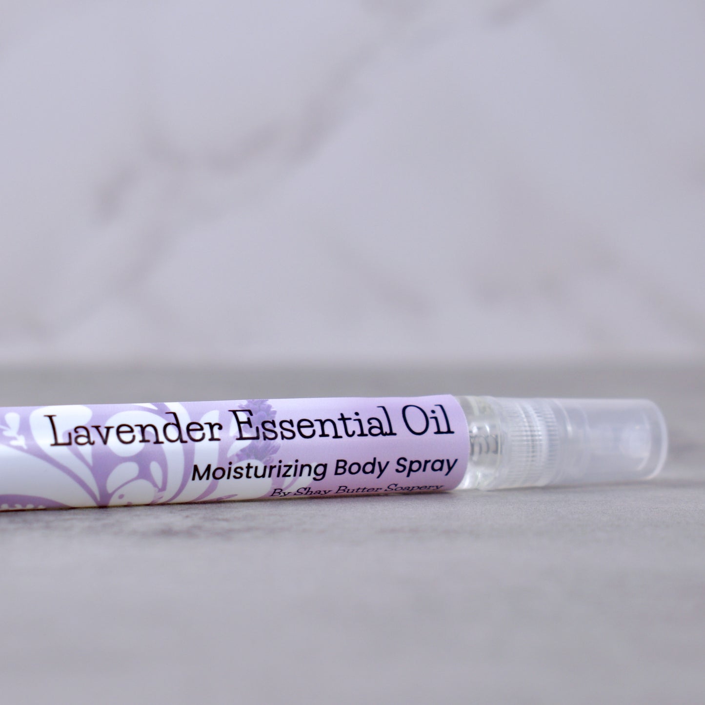 Lavender essential oil moisturizing body spray on a gray background