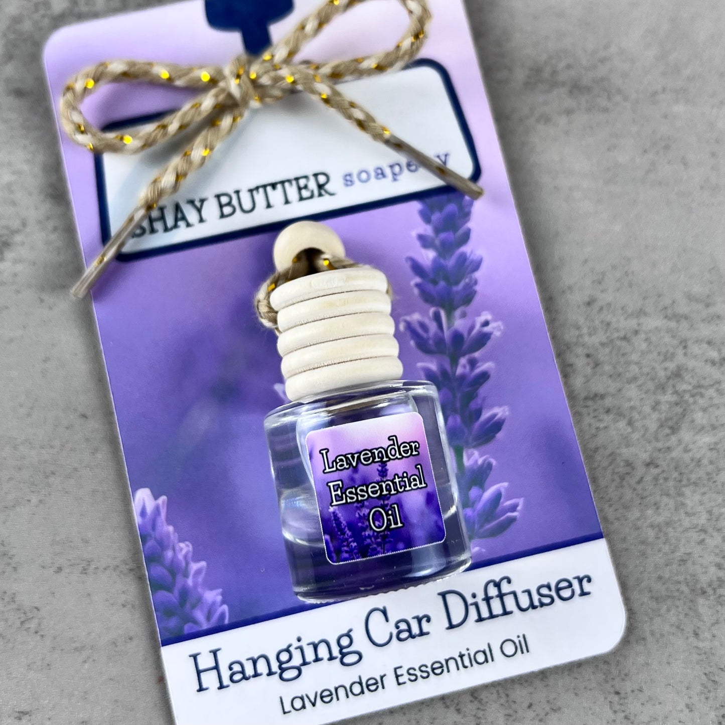Lavender essential oil hanging car diffuser with packaging on a gray surface