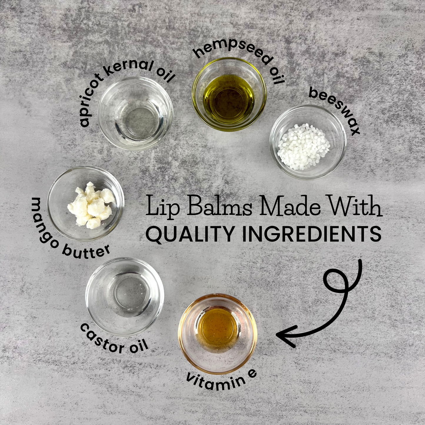 Ingredients for lip balm on a gray surface with labels