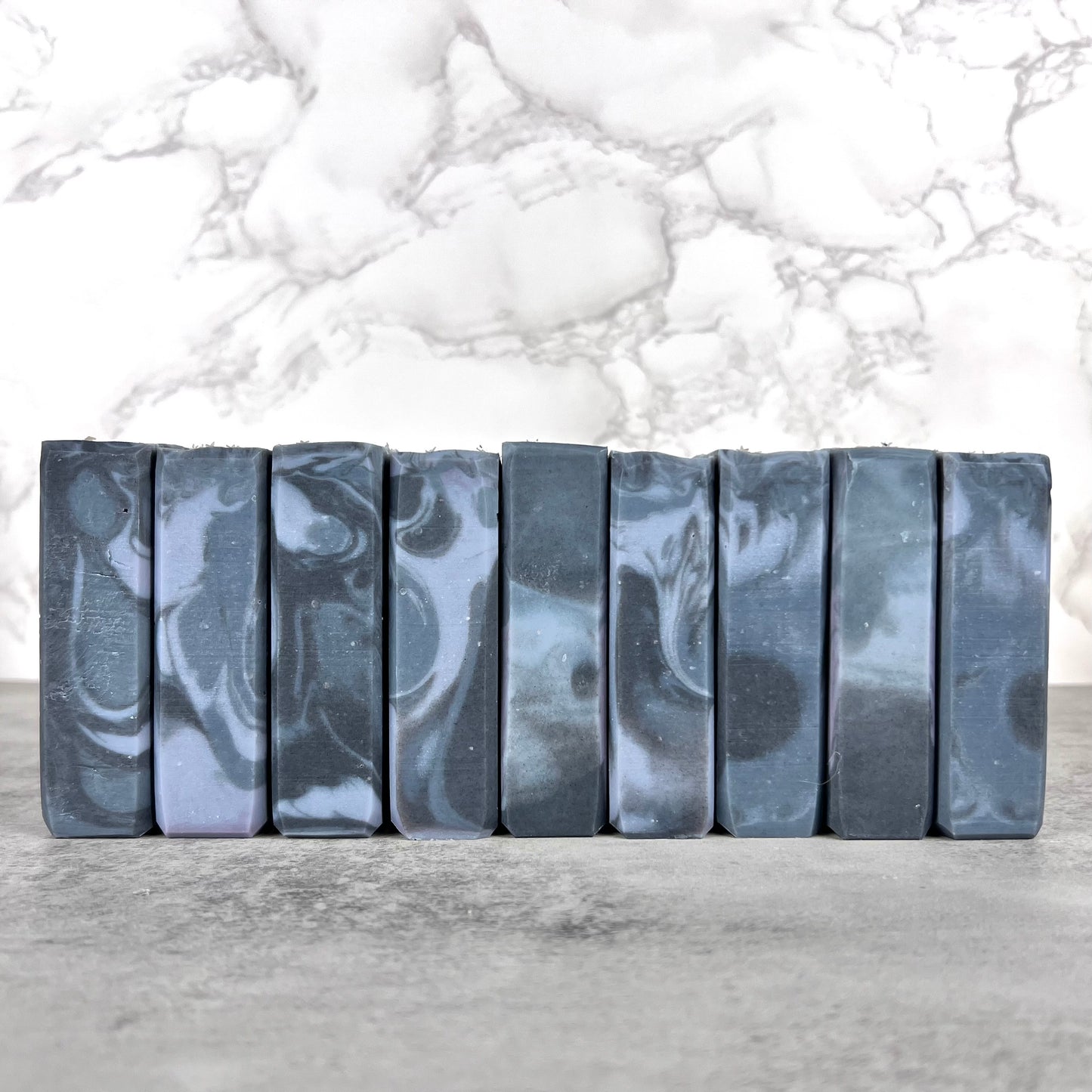Marble-patterned soap bars on a gray surface with a marble background