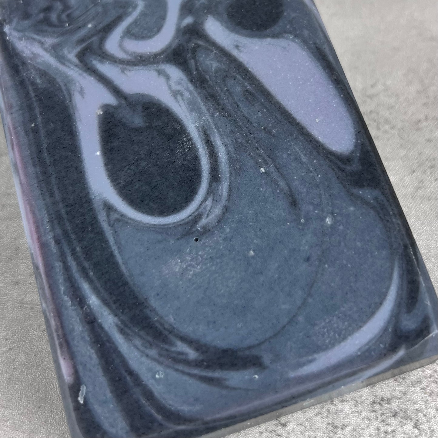 Close up of blue marbled soap on grey surface.