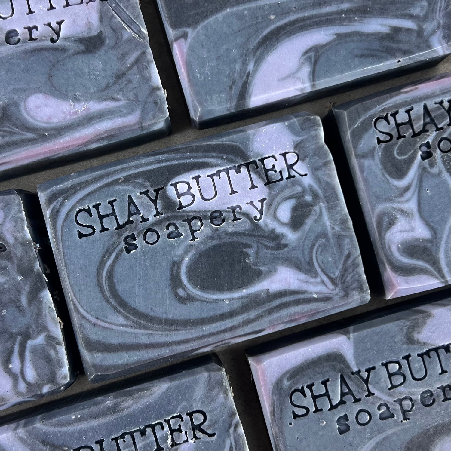 Marble-patterned soap bars with 'SHAY BUTTER soapery' branding.