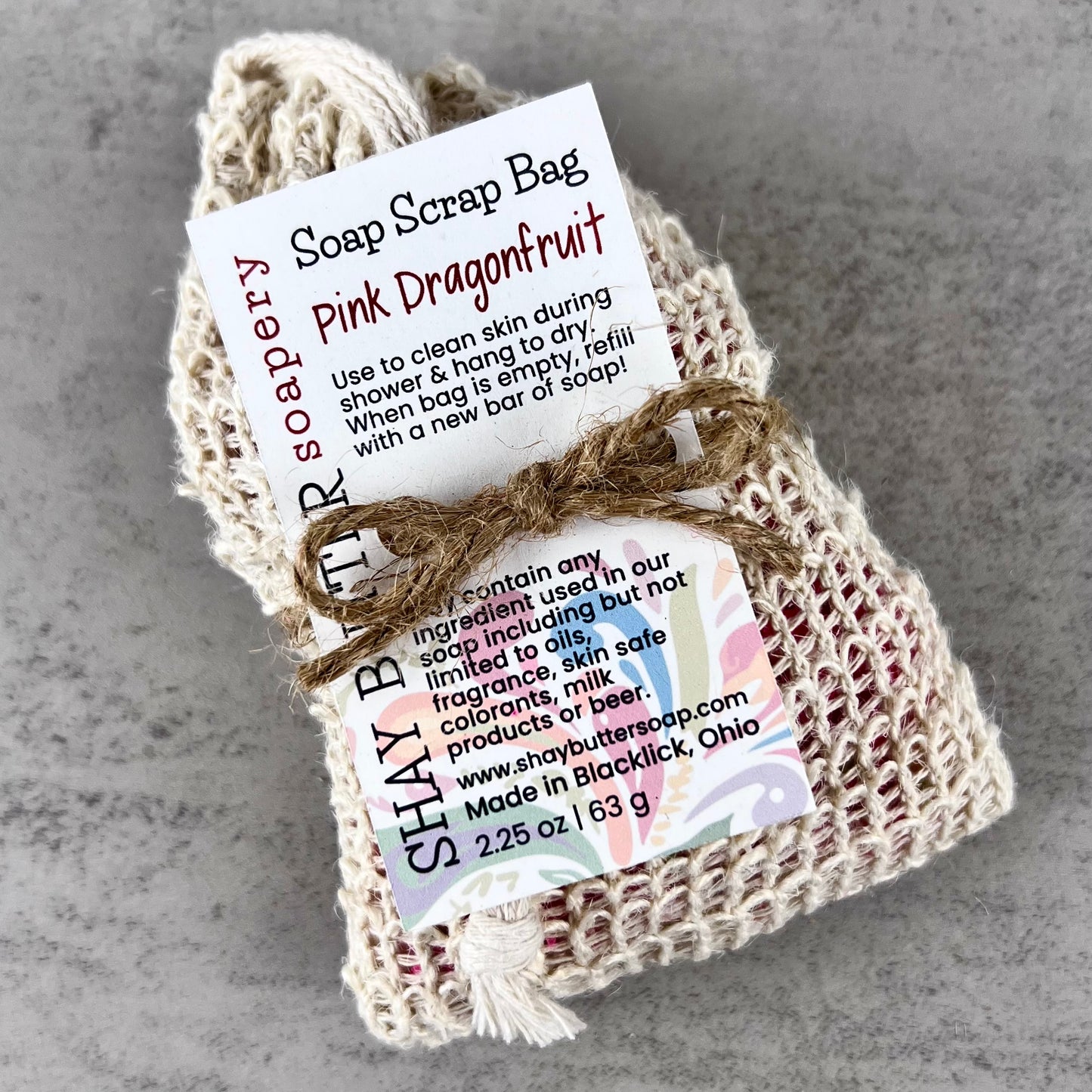 Pink dragonfruit soap scrap bag with a label on a gray background