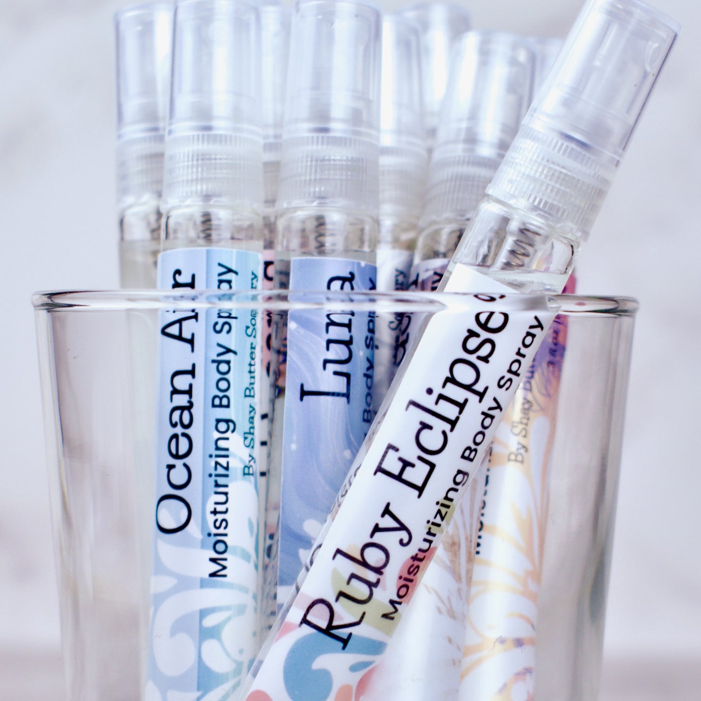Body spray bottles with visible labels on a light background