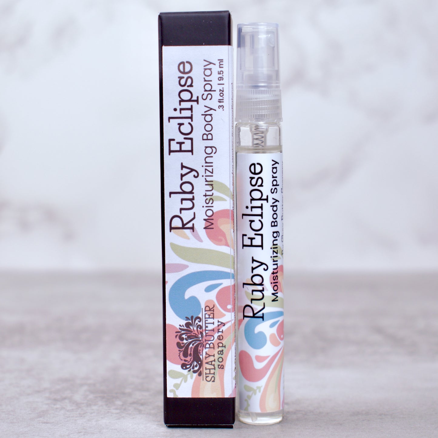Ruby Eclipse moisturizing body spray with packaging on a light gray background