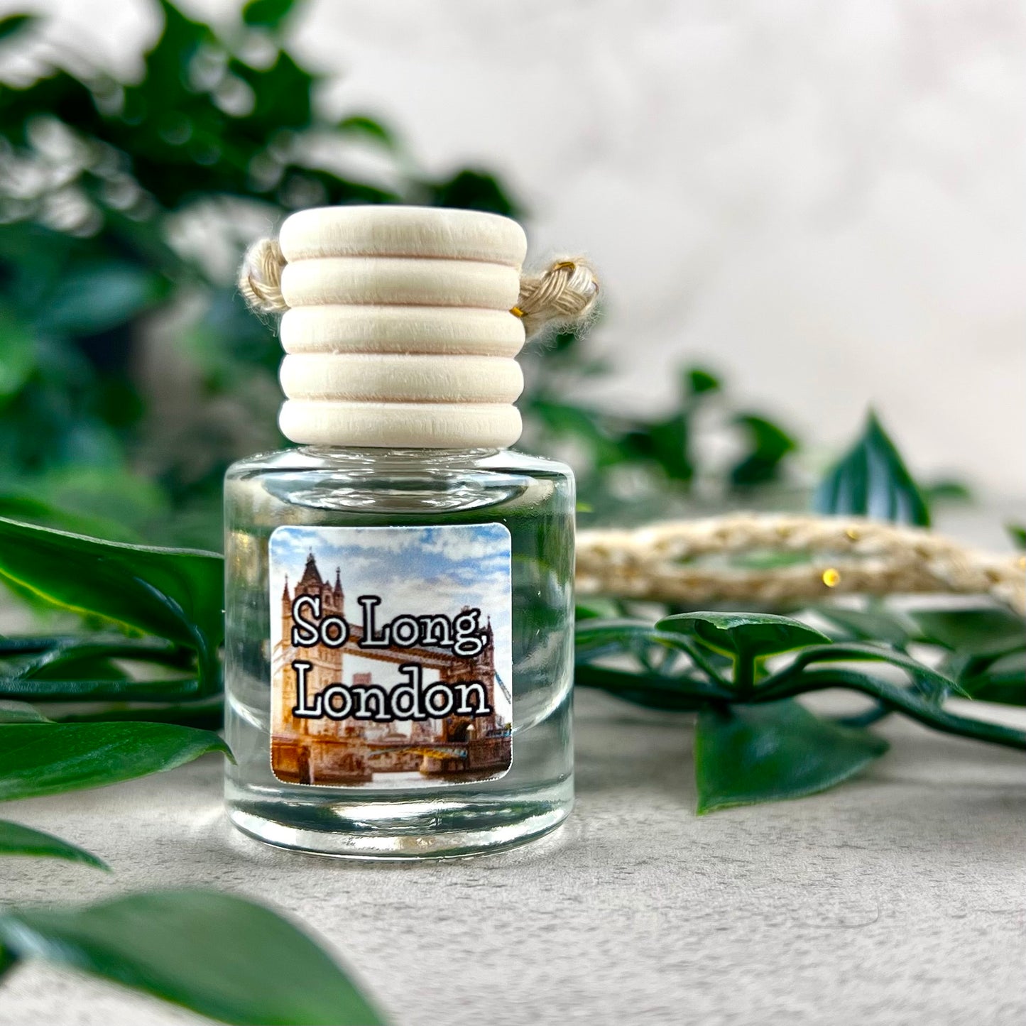So, Long London hanging car diffuser with label on background of greenery.