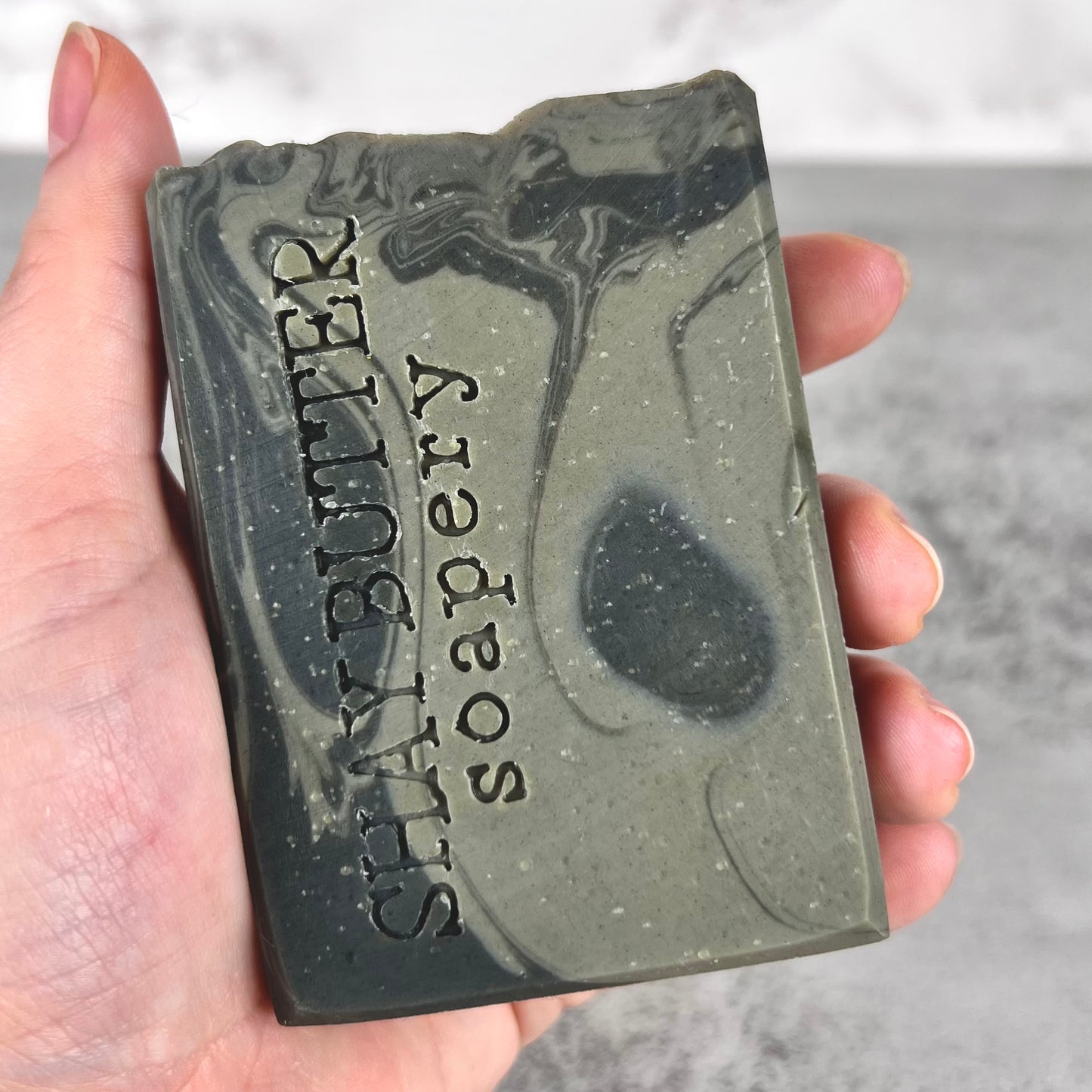 Bar of soap with 'Shay Butter' branding held in a hand against a neutral background