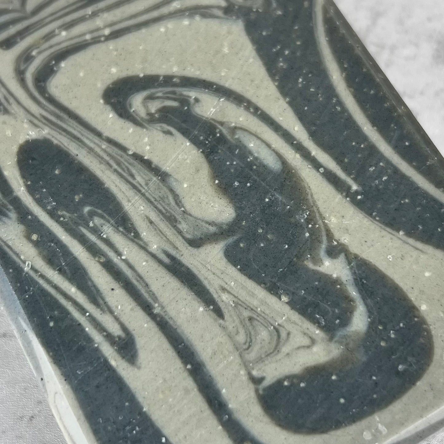 Close-up of a marbled pattern with black and gray colors on a textured surface.