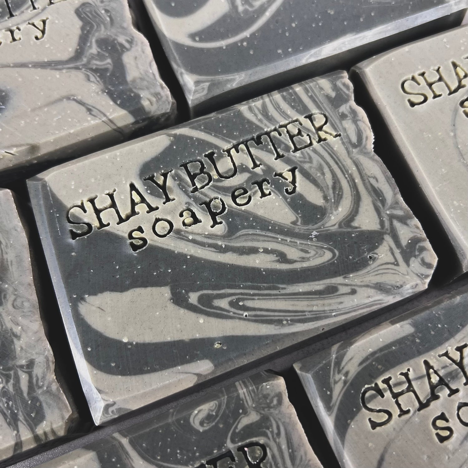 Close-up of multiple bars of Shay Butter Soapery soap with visible branding.