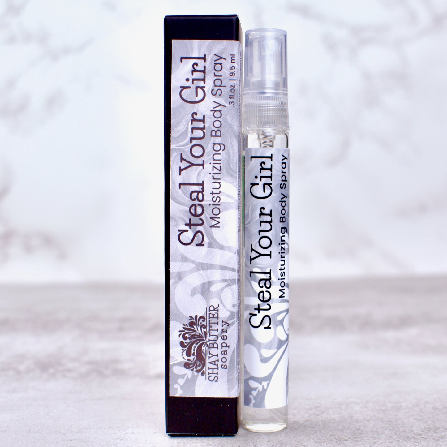 Steal Your Girl moisturizing body spray with packaging on a light background