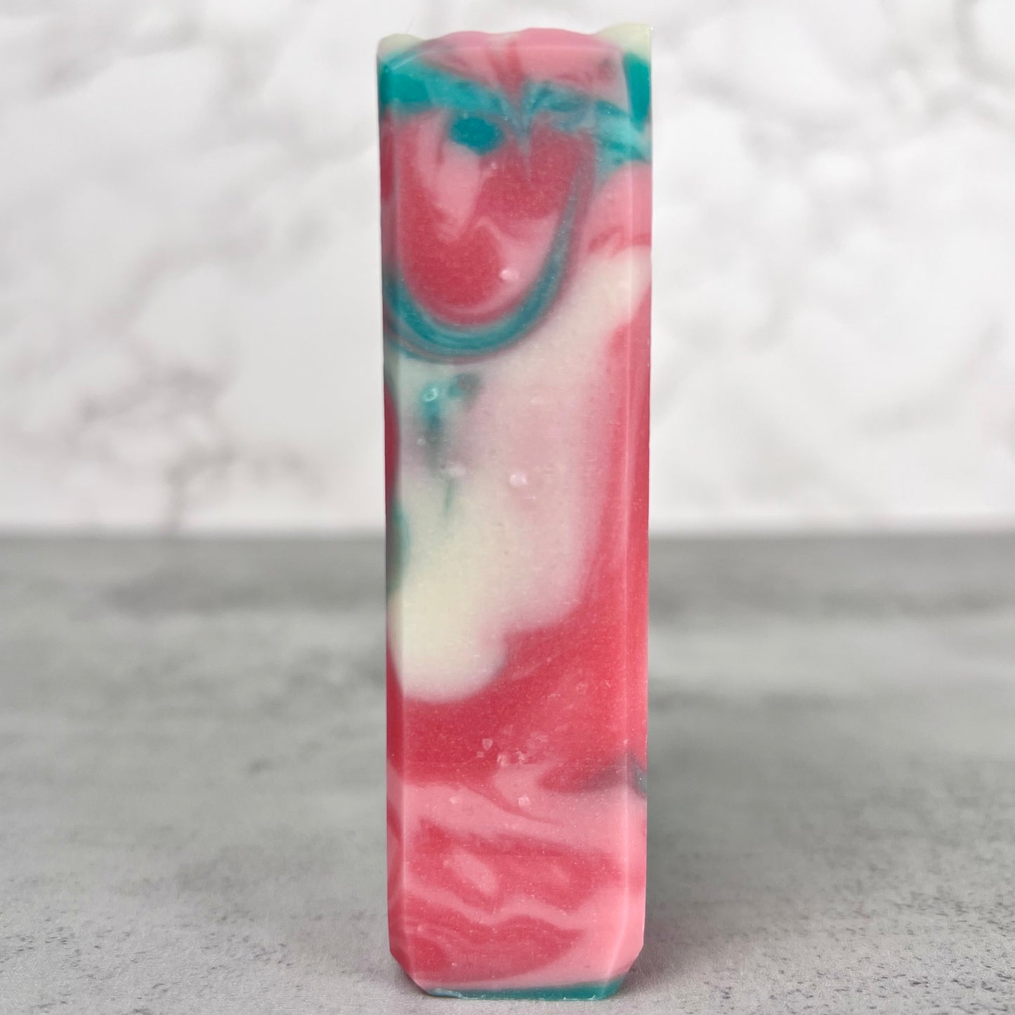 Colorful marbled soap bar on a gray surface with a white background