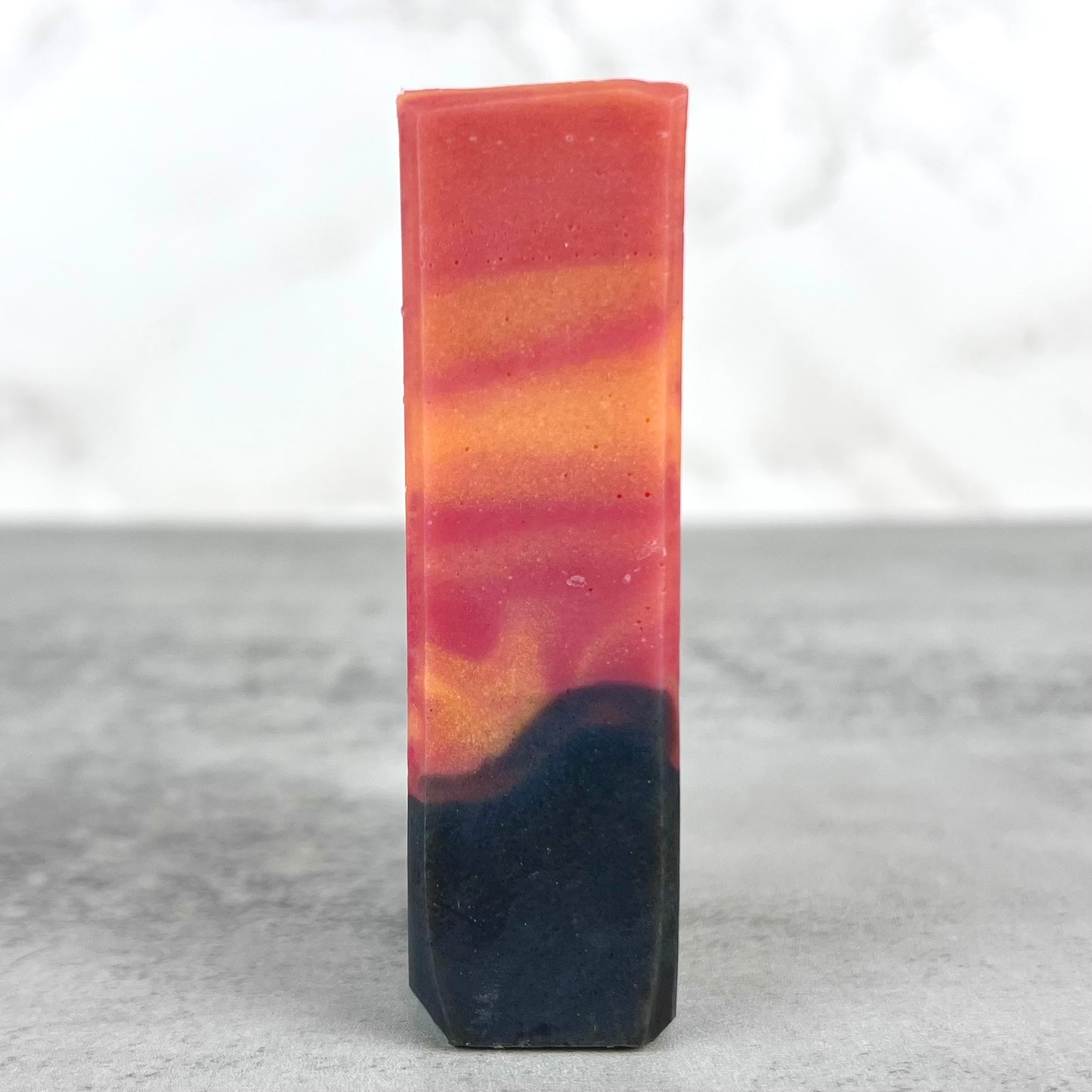 Side view of a sunset inspired bar soap on neutral background