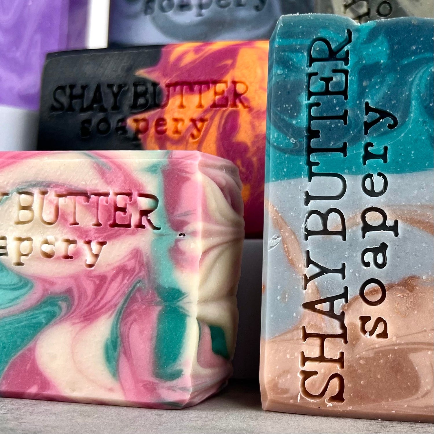A small collection a bar soaps on a grey surface.