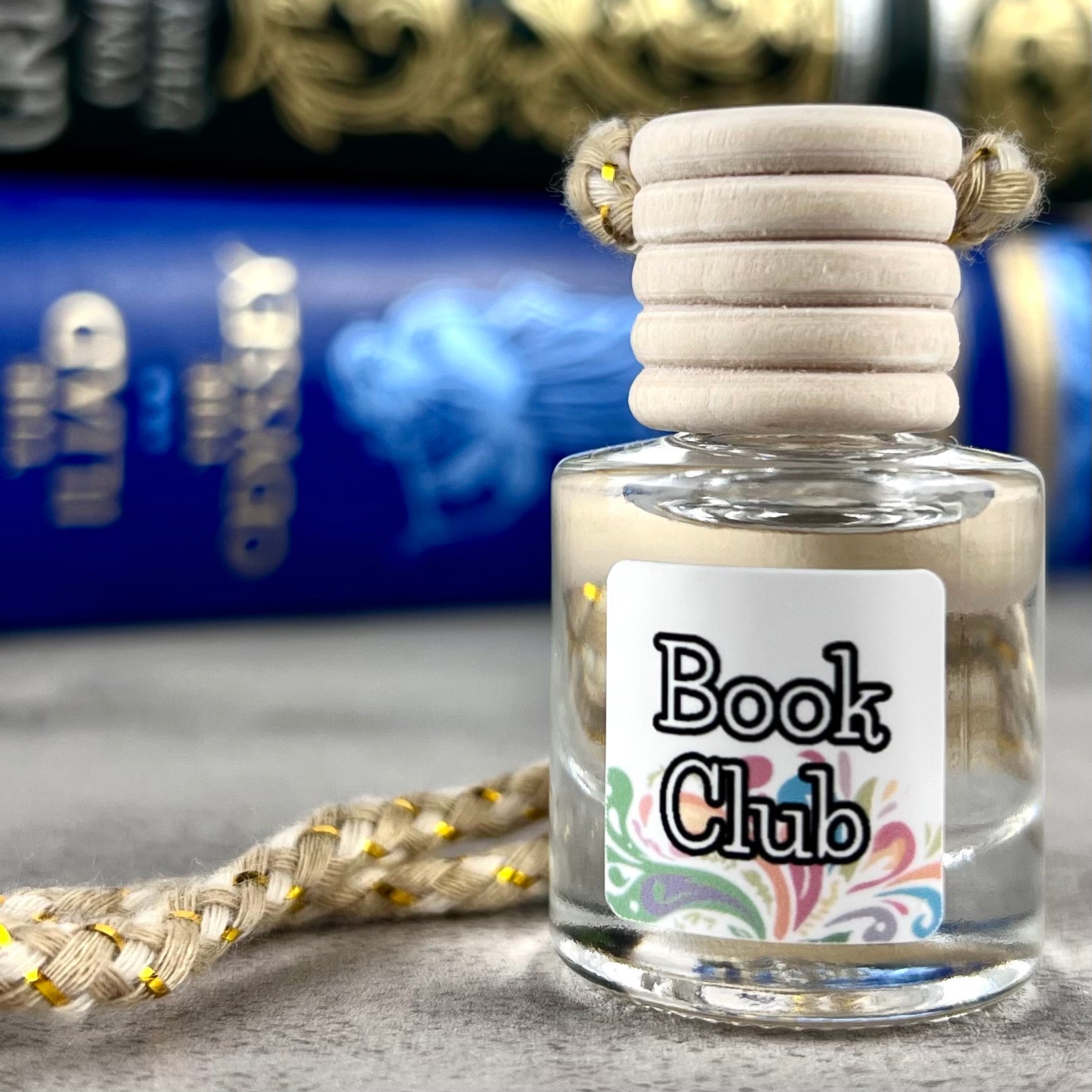 Car diffuser with a wooden cap labeled 'Book Club' on a textured surface.