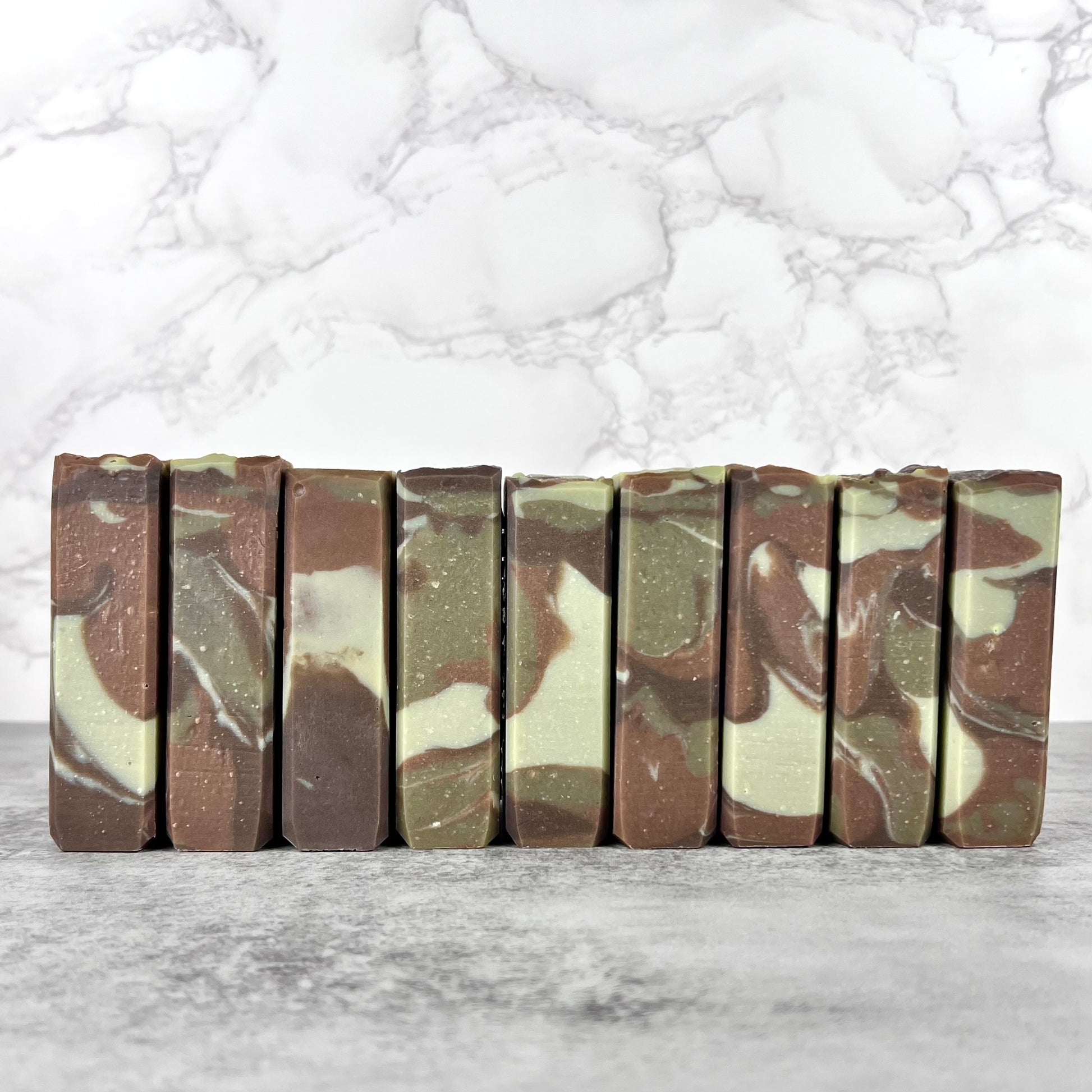 Camouflage-patterned soap bars arranged on a marble surface
