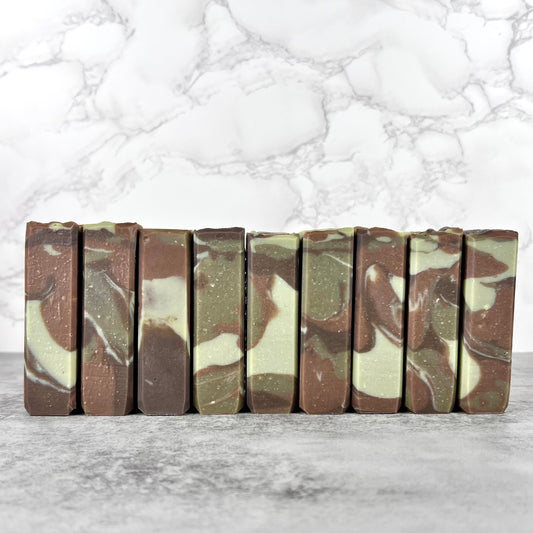 Camouflage-patterned soap bars arranged on a marble surface