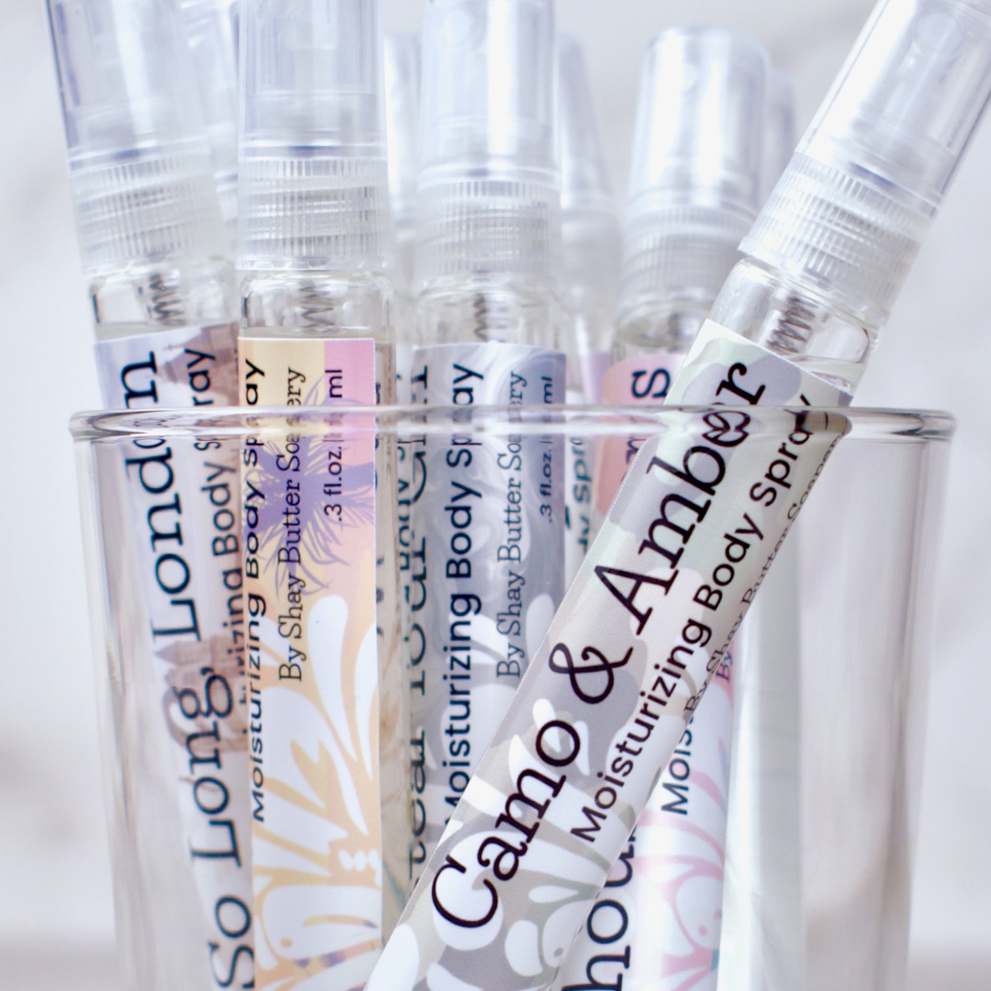 Clear spray bottles with labels on a white background