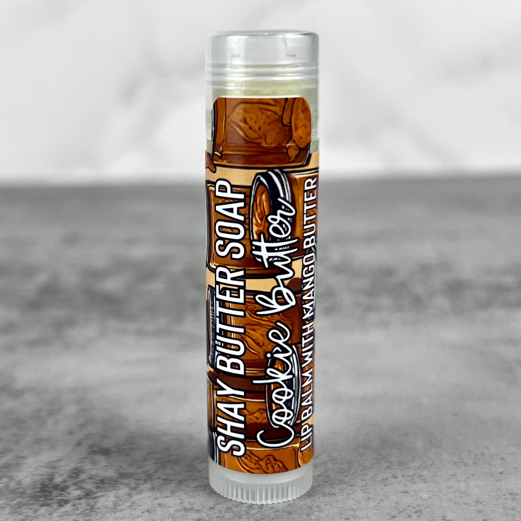 Lip balm with cookie butter flavor on a gray background