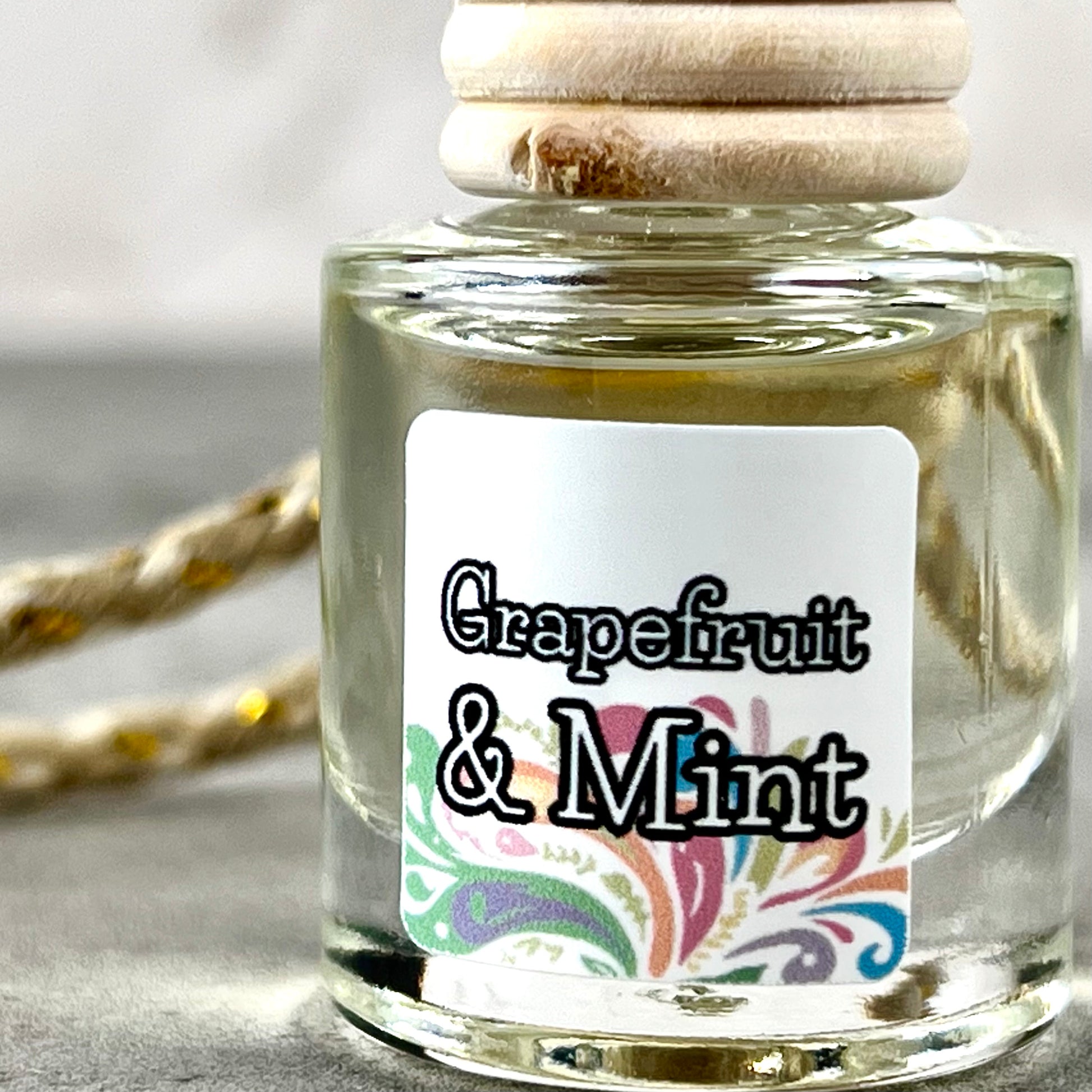 Car diffuser with a wooden cap labeled 'Grapefruit & Mint' on a neutral background