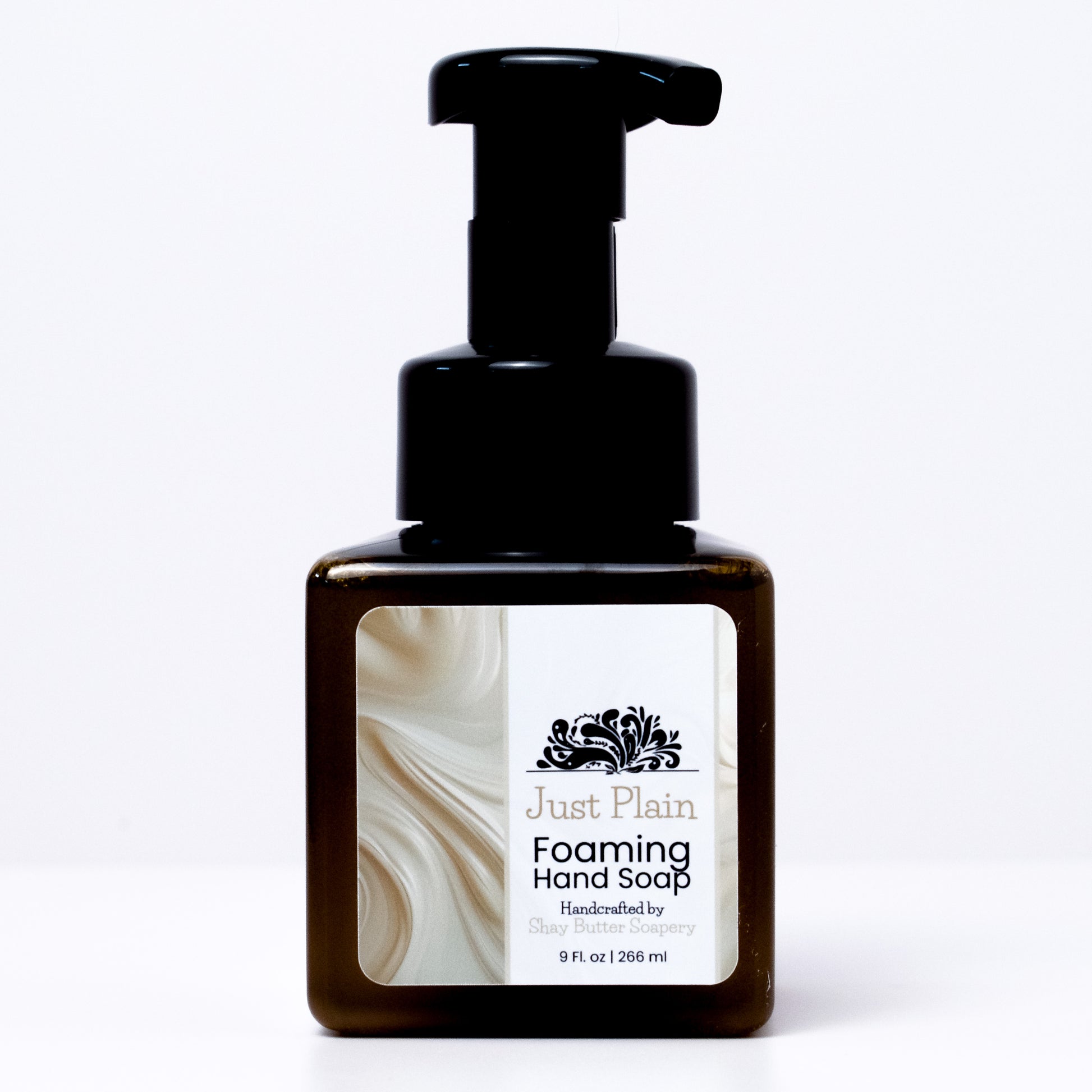 a bottle of "Just Plain" foaming hand soap on a white background