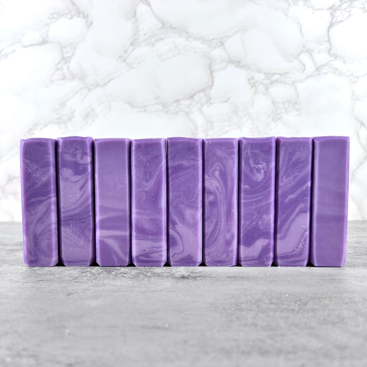 Row of purple soap bars with swirling patterns on a marble surface