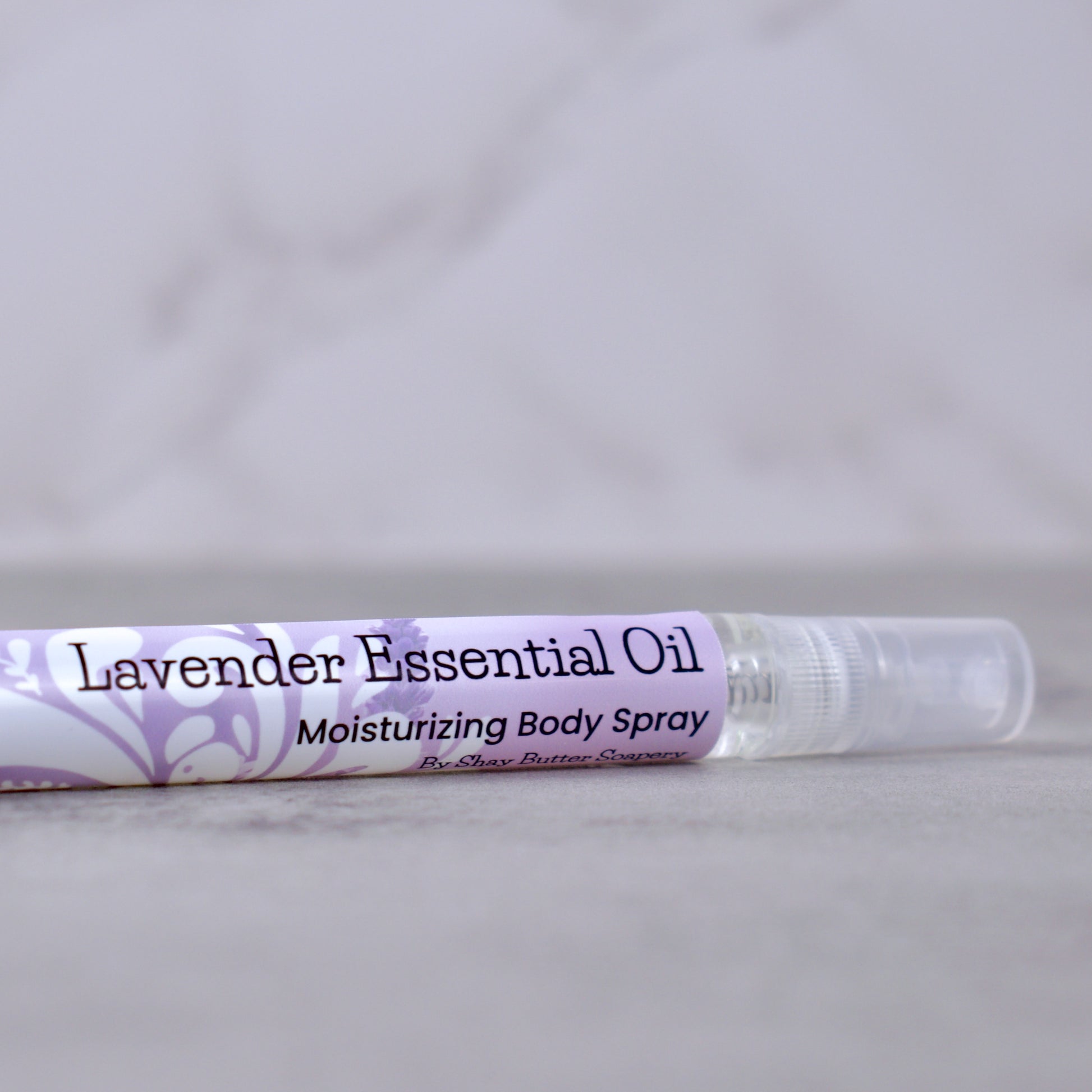 Lavender essential oil moisturizing body spray on a gray background