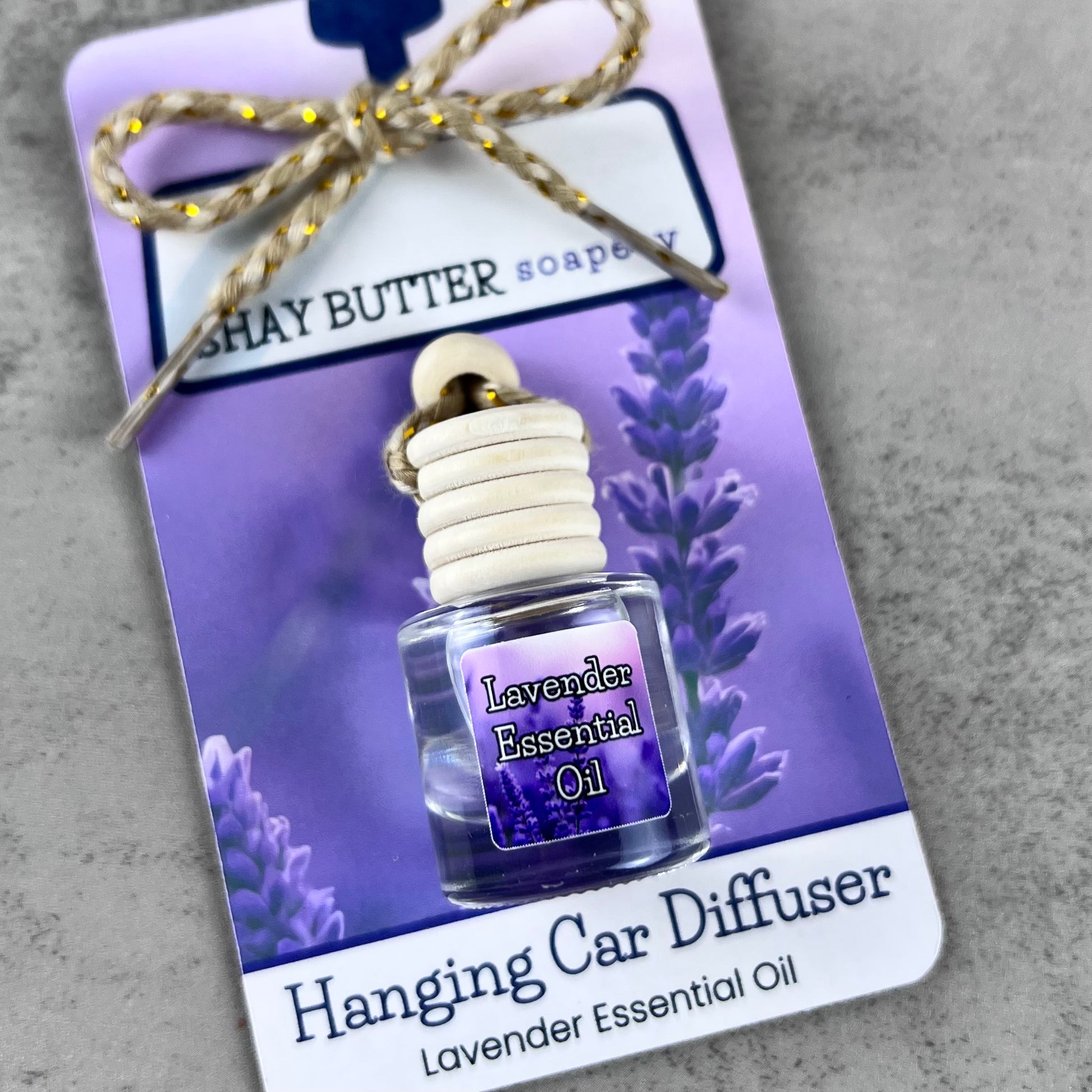 Lavender essential oil hanging car diffuser with packaging on a gray surface