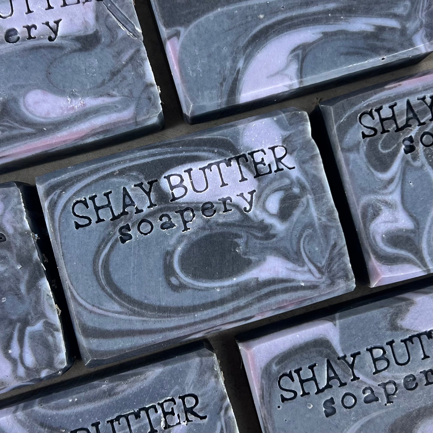 Marble-patterned soap bars with 'SHAY BUTTER soapery' branding.