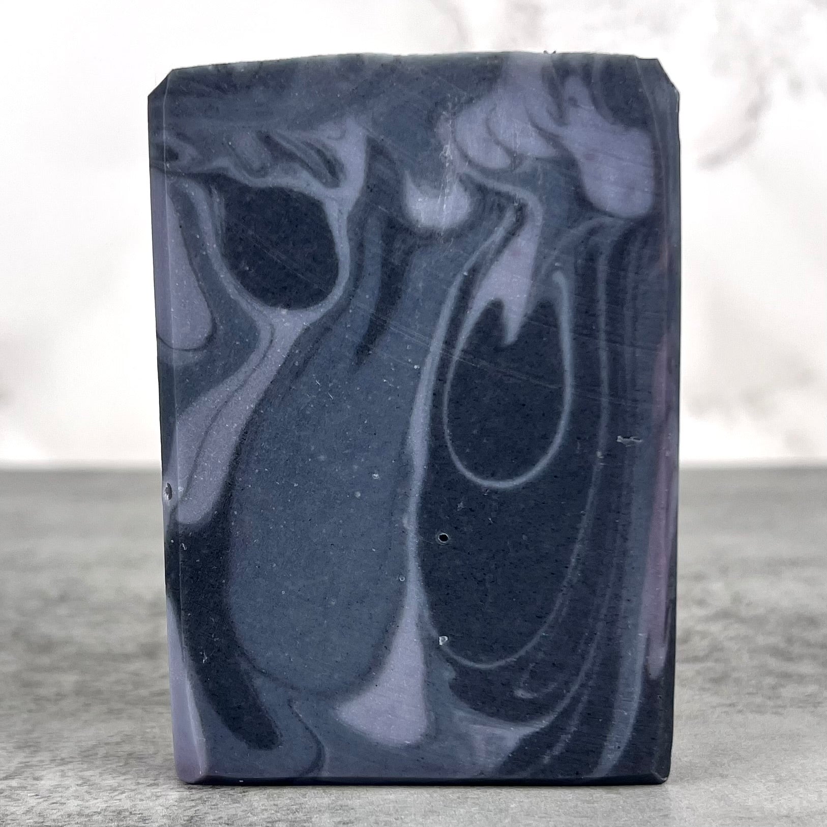 Bar of soap with blue marbled pattern on a neutral background