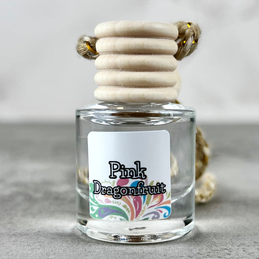 Car diffuser labeled 'Pink Dragonfruit' with a wooden cap on a neutral background