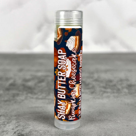 Lip balm tube with pumpkin cheesecake flavor on a gray background