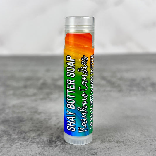 Lip balm with a rainbow-colored label on a gray surface