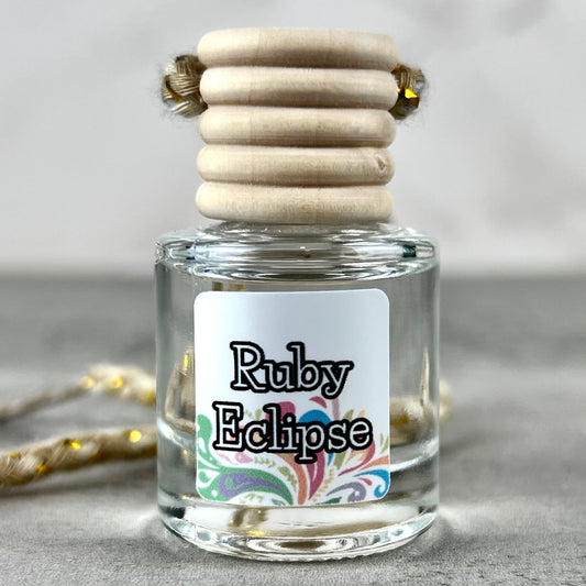 Hanging car diffuser labeled 'Ruby Eclipse' with wooden elements on a neutral background