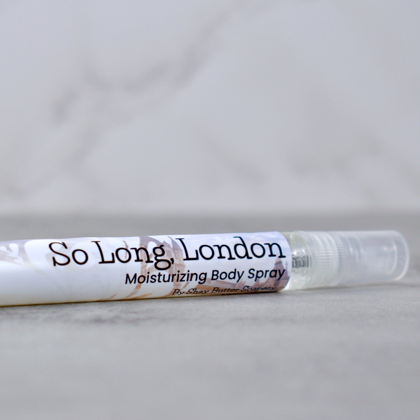 a bottle of "so long, london" moisturizing body spray on grey surface