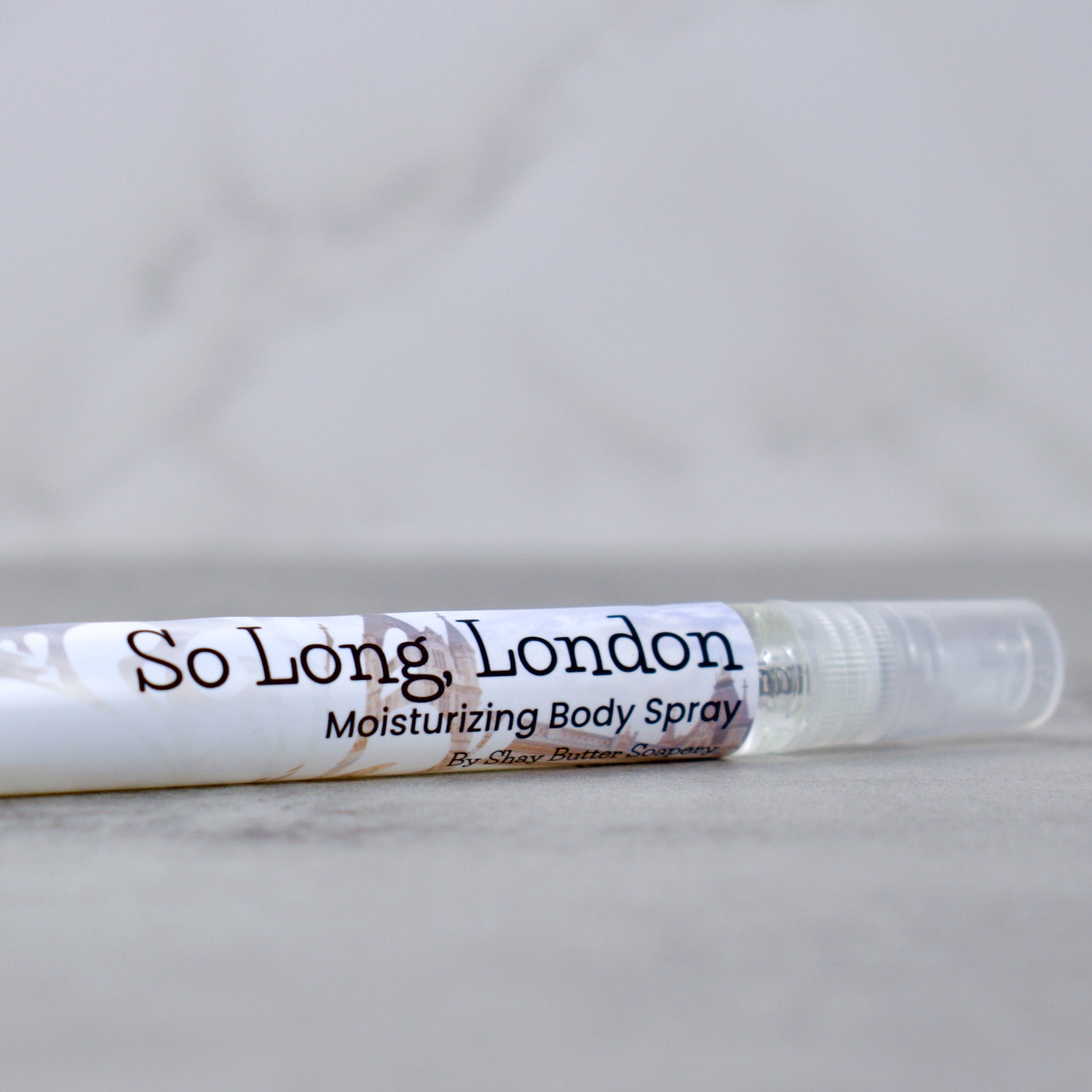 a bottle of "so long, london" moisturizing body spray on grey surface