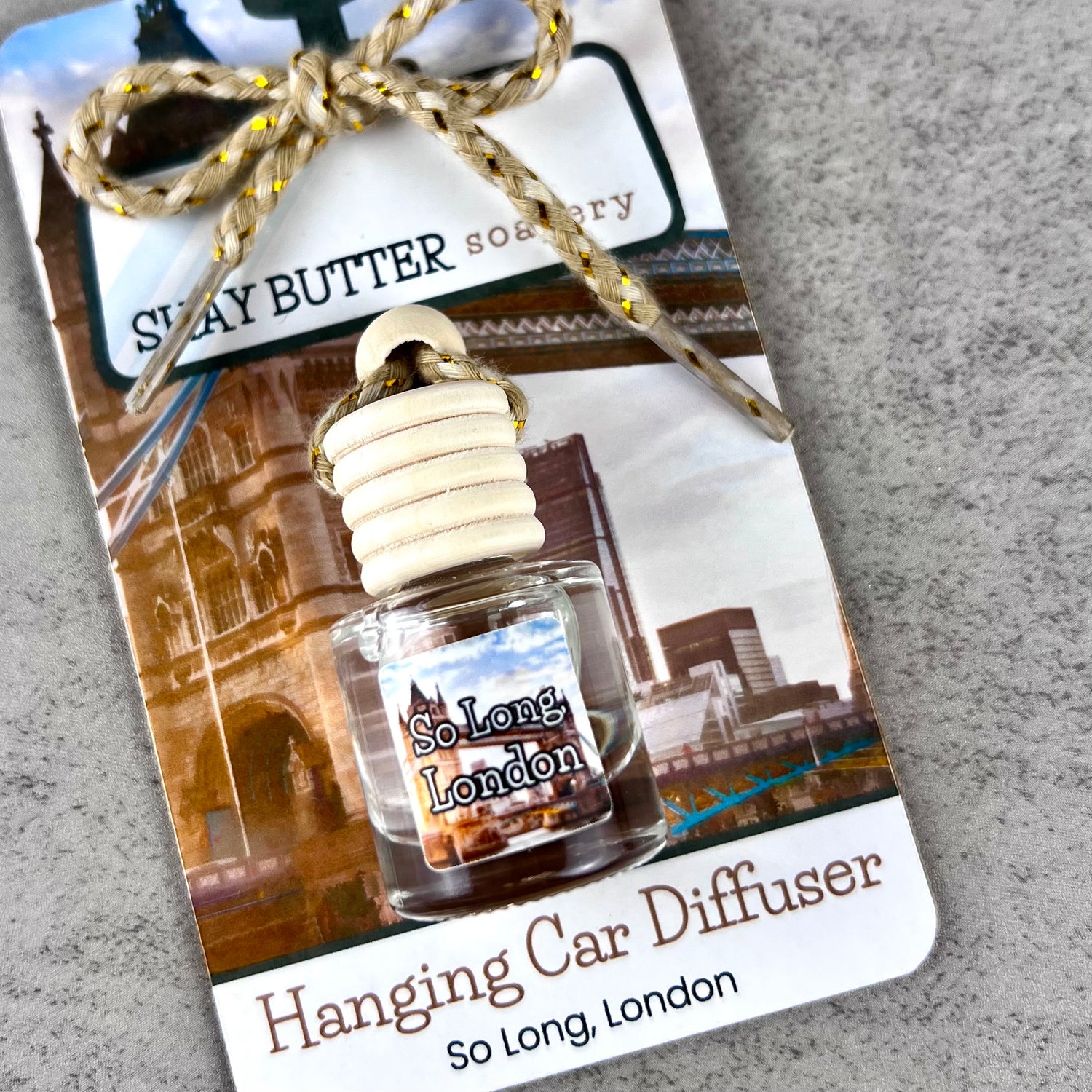 Hanging car diffuser with 'So Long, London' label on a decorative packaging card.