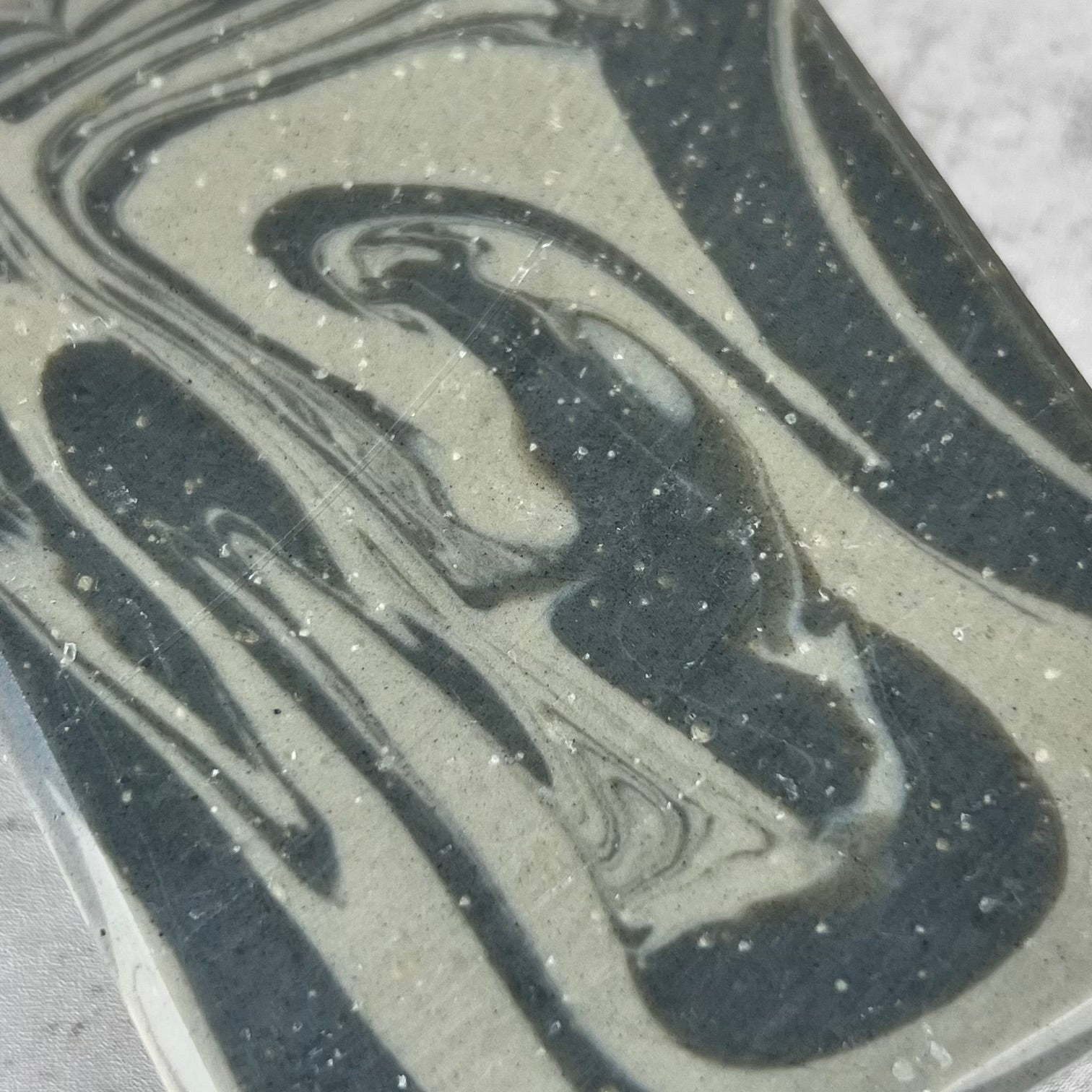 Close-up of a marbled pattern with black and gray colors on a textured surface.