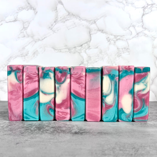 Marbled soap bars in pink, blue, and white on a marble background