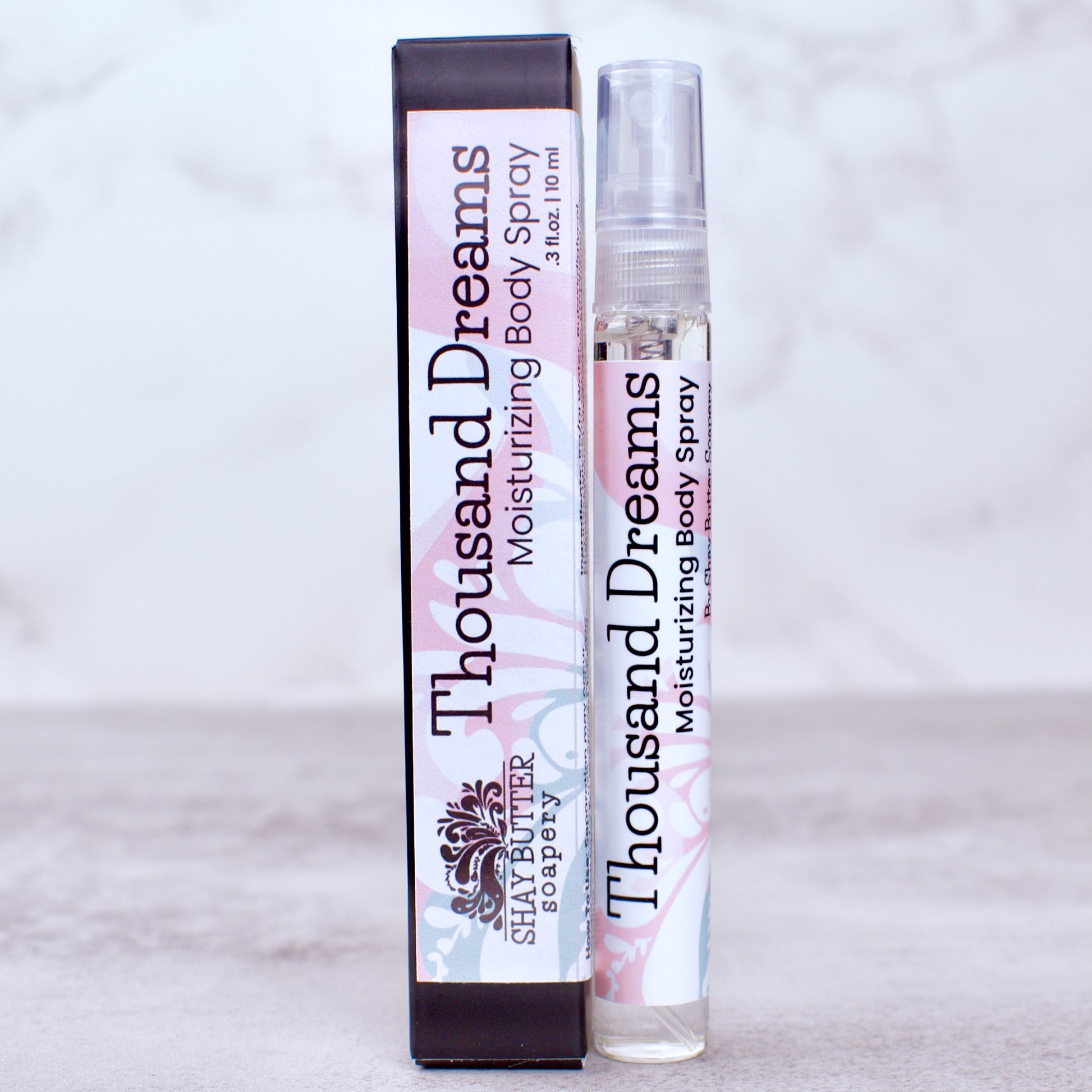 Thousand Dreams moisturizing body spray with packaging on a light gray background